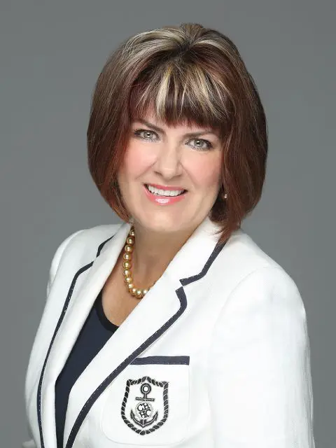 A woman with brown hair and wearing a white jacket.