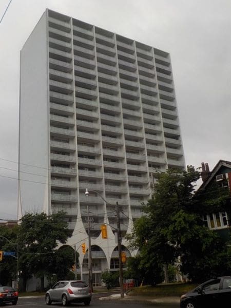 A tall white building with many balconies on top of it.