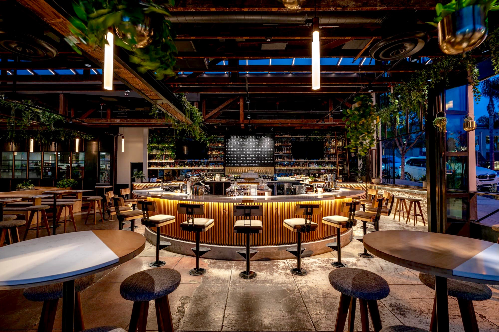 A bar with many stools and tables in it